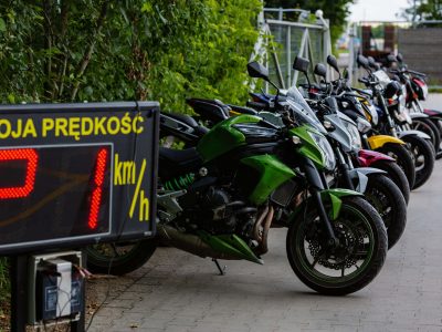 Na pierwszym planie licznik prędkości. W tle szereg motocykli do nauki jazdy